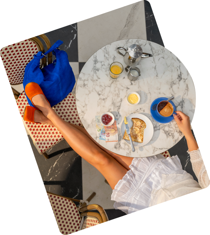 Person with feet on chair at marble table with coffee